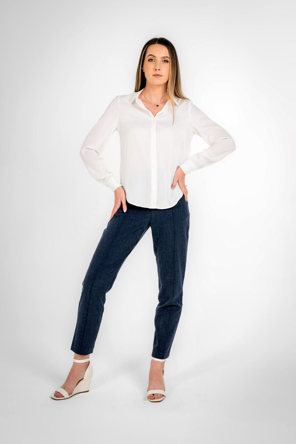 Woman wearing a white shirt and navy blue pants  